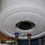 The underside of a water heater that’s leaking and in need of repair.